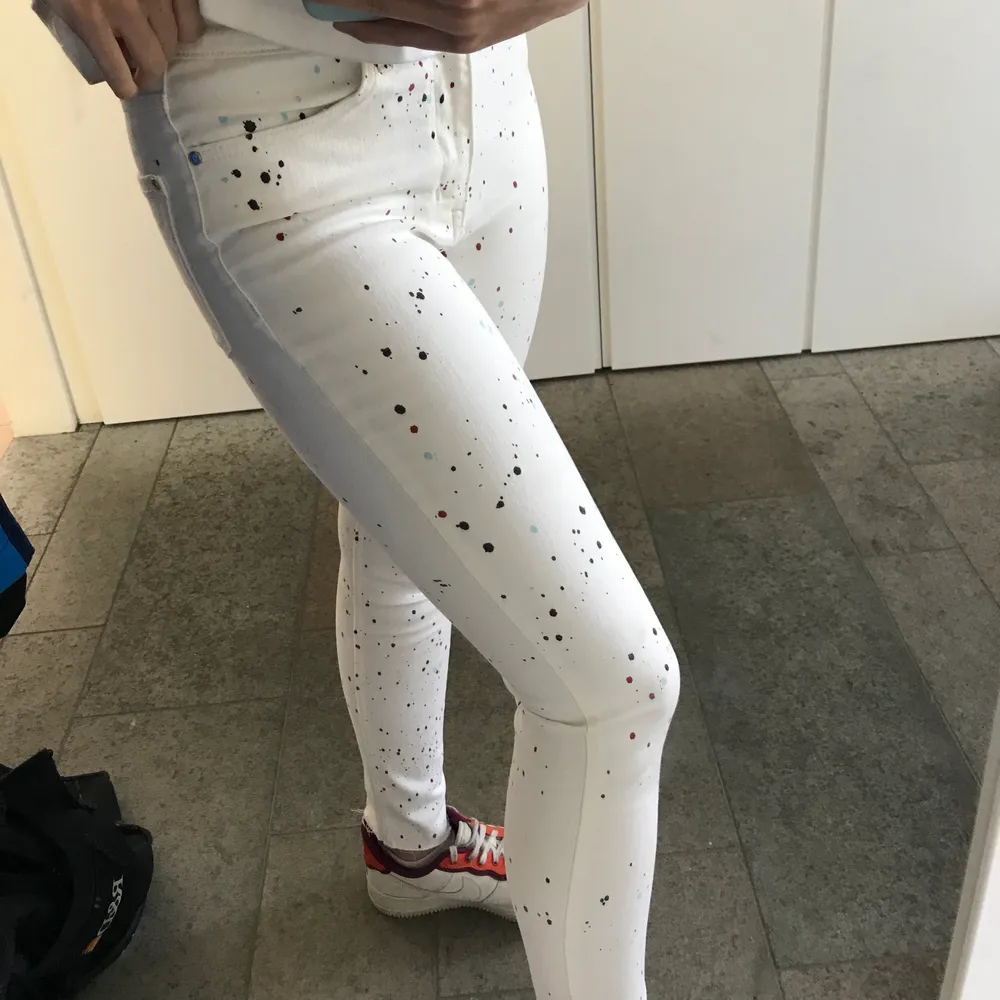 Vita jeans med färgstänk i svart, rött och turkos. De är i strl 38 men skulle säga att de passar xs/s! Endast använda 2 gånger. . Jeans & Byxor.