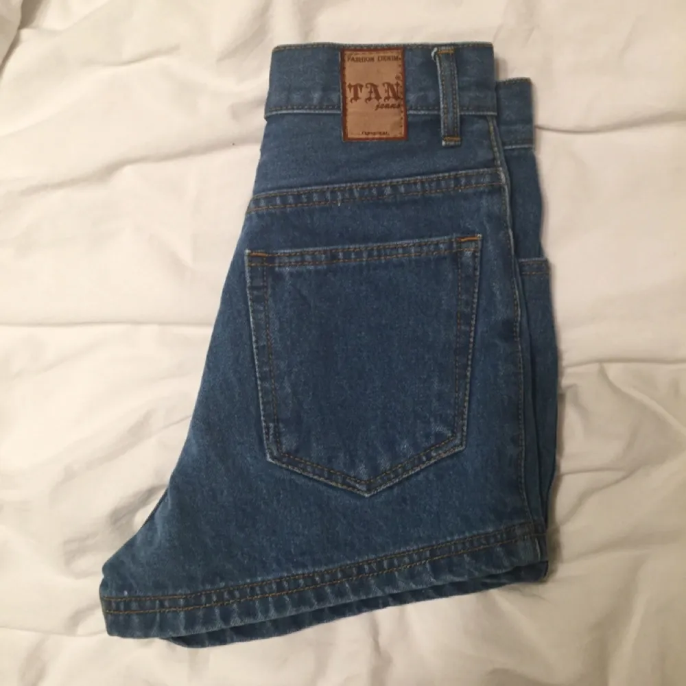 Blåa jeansshorts i riktig jeans-material. De är små i storleken och passar en XS eller liten S men står S i byxan. Shortsen är från märket Tan Jeans. 

. Shorts.