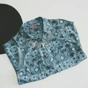 Armlös blus från H&M, ljus blå i färgen med gråa detaljer, passar S/M, sparsam använd! 