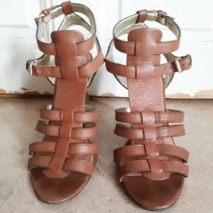  - Ljusbruna gladiatorsandaler i läder och kilklack i trä. US size 8 vilket motsvarar storlek 38-39. Sparsamt använda och i fint skick!