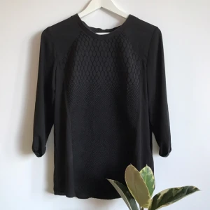  - Något transparent i ryggen och armarna. 