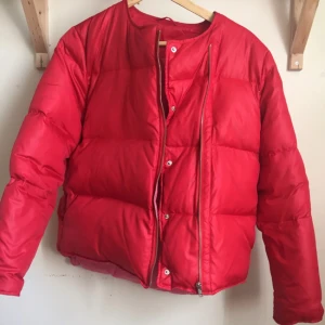  - Finaste Acnejackan. Röd dunjacka med rosa foder. Biker-knäppning och två fickor samt en innerficka. Knappt använd! Det är en tunnare jacka, perfekt vår/höst.   