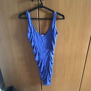 En blå töjbar klänning som formar kroppen väldigt bra, speciellt vid rumpan Tar swish