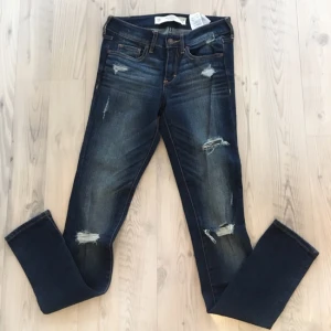  - Abercrombie & fitch jeans storlek 24, längd 31.  Inköpta i Paris för 2 år sedan, sparsamt använda och bra skick men säljs nu för att de är för små. En utav slitningarna har gått upp lite (se bild).  Kan mötas upp (Åkersberga & Täby) och tar swish. 