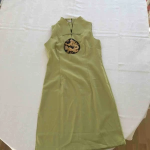  - Vacker grön klänning köpt i Kina. Fint guldbroderi av drake. Slits på ena sidan som dock gått upp lite (se bild 3).