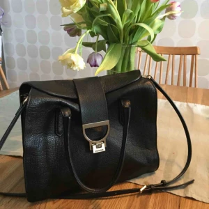  - Klassisk, supersnygg väska från Italienska modehuset Coccinelle, en Arlettis tote bag. Helt slutsåld! Nypris 4300kr, inköpt 2014, Harrods London. Väl omhändertagen så mindre skönhetsfel men inget som syns utan lupp. 