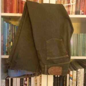  - Ett par militärgröna levi’s jeans, väldigt bra skick, knappar i stället för gylf