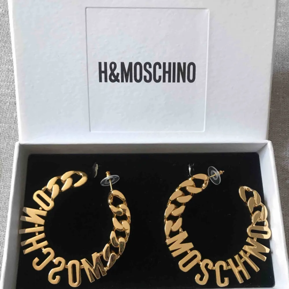 Helt oanvända MOSCHINO [TV] H&M örhängen i guldpläterad metall formad med bokstäverna 