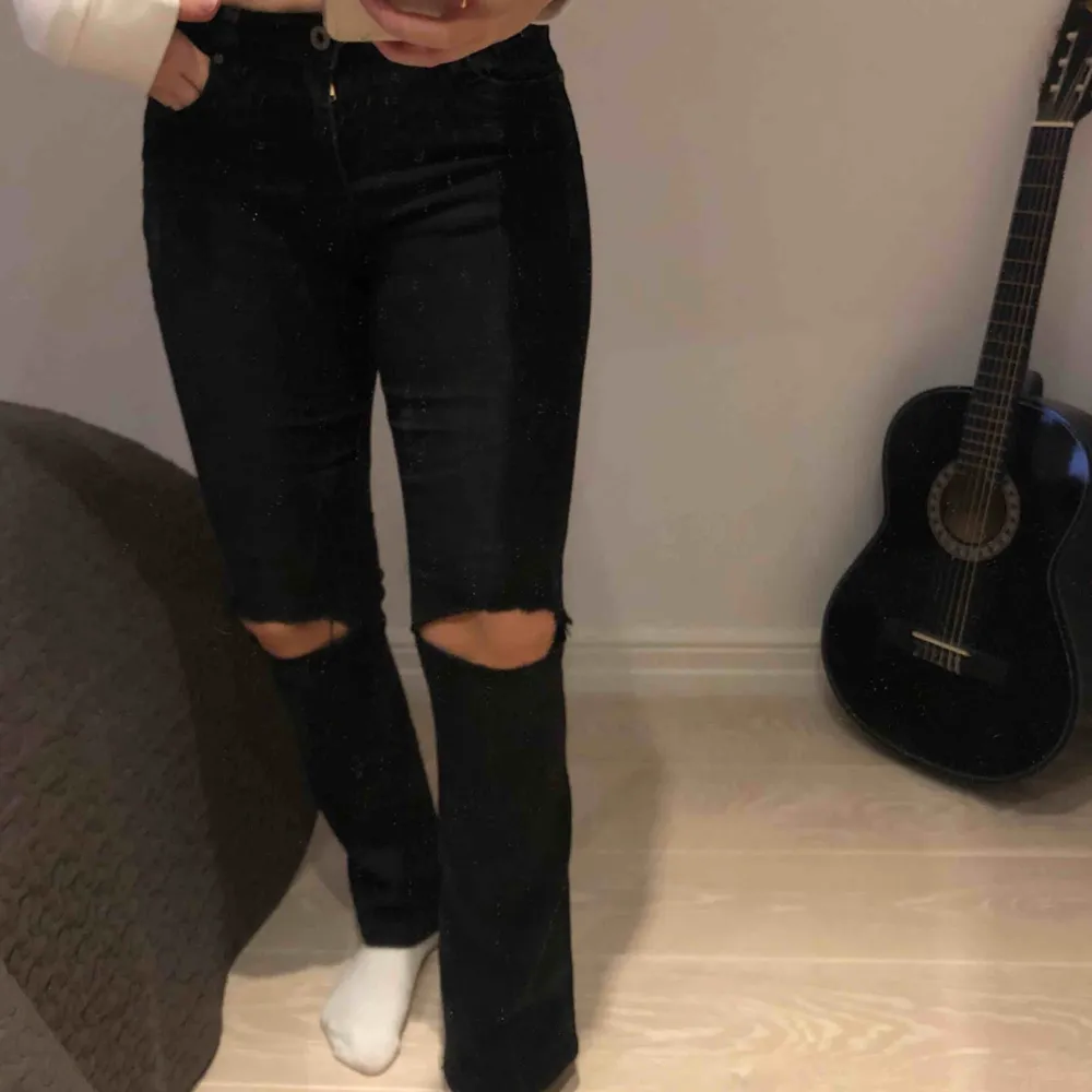Svarta bootcut jeans med hål på knäna. Väldigt bra skick!. Jeans & Byxor.