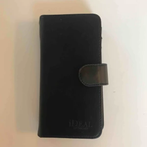  - iDeal of Sweden svart skinnskal med magnet som jag endast hann och använda i ett par veckor. Väldigt bra skick, skickar med kartongen den kom i. Köparen står för frakt. 