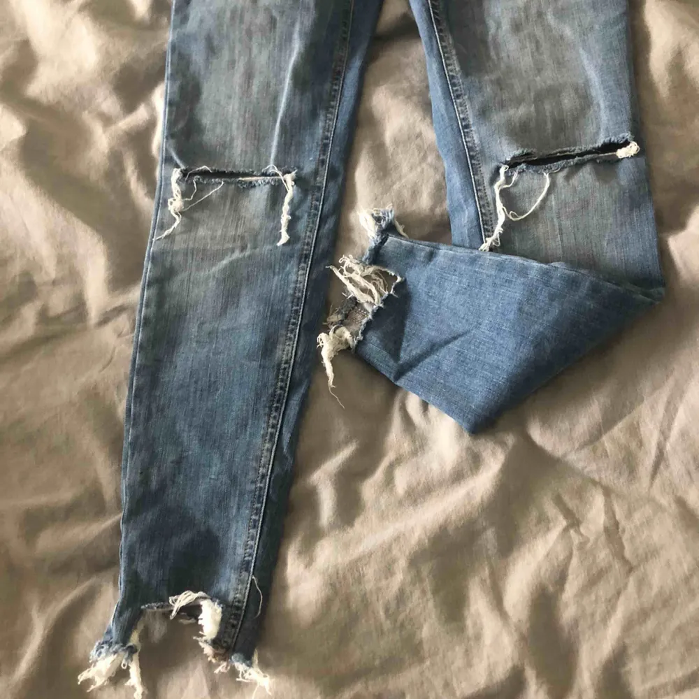 snygga jeans med hål på knäna och snygga slitningar längst ner . Jeans & Byxor.