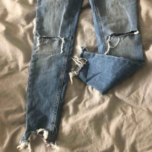  - snygga jeans med hål på knäna och snygga slitningar längst ner 