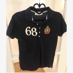  - Säljer mörkblå piké med logga från Morris lady. Använd 1 gång, i storlek S, nypris 800:- 