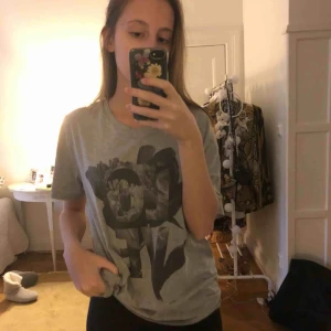  - T-shirt från Weekday. Gråfärgad med mönster på framsidan. Skicket är som nytt. Kom gärna med egna priser som ni skulle kunna tänka er betala för denna T-shirt ❤️