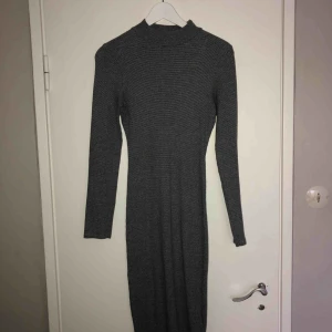  - Tight klänning som går precis över knäna. Följer former bra. 