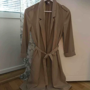  - Oanvänd kappa från H&M den är tunn och köpt i början på sommaren, passar en storlek S. Den har uppsydda armar och guldiga detaljer. 