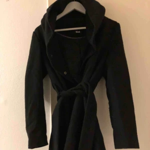  - Lång svart kappa med stor luva och skärp. Fint skick. Köparen står för frakten.