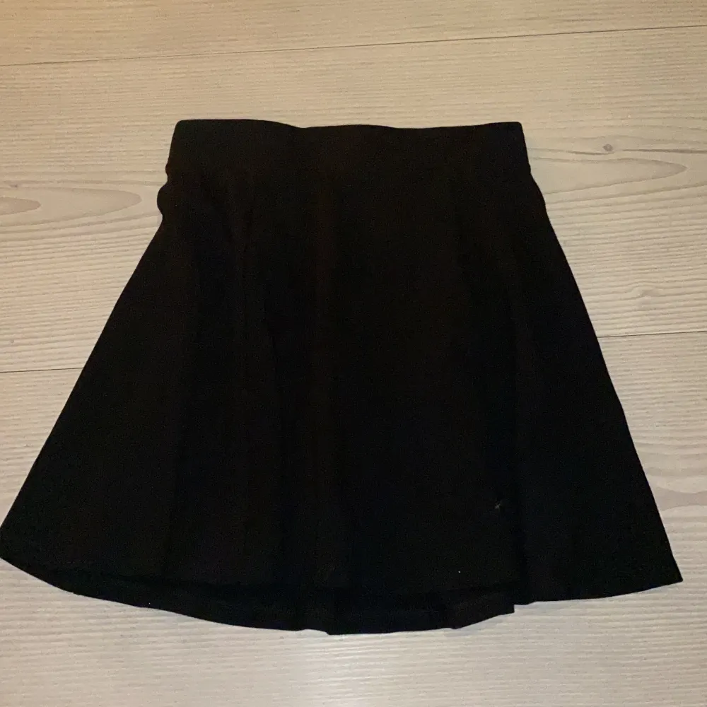 Svart kjol från HM, slappt och lite stretchigt material, den har en slapp passform förutom runt midjan då den sitter tajt, den har en silvrig dragkedja på baksidan så går nästan halvvägs ner, aldrig använt.. Kjolar.