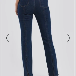 Blå jeans med slits, storlek 34 - Mörkblå jeans från Na-kd. Söm oxh slits baktill, använda enstaka gånger men säljer pga att de är för stora. ♥️ Frakt tillkommer. 