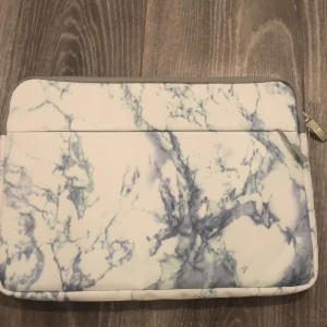 Datafodral marmor - Fint datafodral i marmor. Aldrig använt. Har ett framfack med två små fack. Mjukt inuti som dämpa stötar. Mått : 35x25 cm. Köparen står för frakten. Fraktar endast.