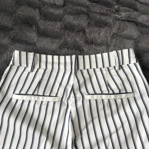 Kostymbyxor  - Mörkblå/vit Randiga kostymbyxor från HM. Storlek 36. Väldigt stretchiga och har en dragkedja på sidan vid höften samt två ”låtsatsfickor” på rumpan.