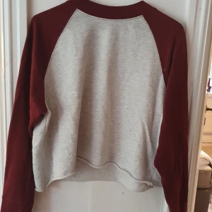 Cropped sweatshirt - Croppad sweatshirt från H&M i vitt och vinrött. Köpt på H&M för några år sen men i bra skick! ⭐ Storlek L, men fungerar toppen som en oversized S. Säljs då den inte används. Kontakta vid frågor/intresse 💜 frakt inräknad
