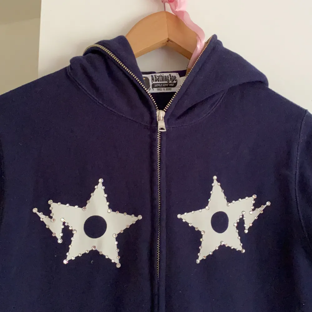 Supersnygg hoodie från BAPE, endast använd en gång. Mörkblå med tryck på ryggen och har strass stenar på framsidan. Passar xs-s. PRIS KAN DISKUTERAS VID SNABB AFFÄR. Hoodies.