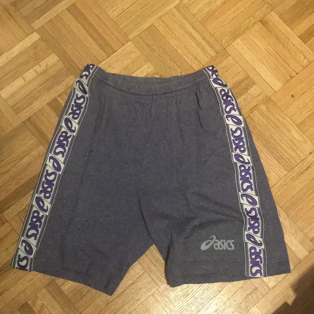 Asics shorts köpt på humana. De är grå/lila och i väldigt mjuk och stretchig material. Det står ingen storlek på lappen men skulle säga M-L men skulle även passa en S om man vill ha lite oversize. Har självt aldrig använt dom. Pris kan diskuteras. Shorts.