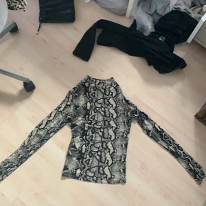 En tunn stretchig långarmad tröja - En tunn tröja men ormmönster, från Gina tricot 
