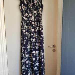 Klänning MQ, Stockh lm  - En otroligt fin klänning med blekt rosa blommor,ljust gröna blad på mörkblå botten. Köpt på MQ,märket STOCKH LM och endast använd vid ett tillfälle,superfin. Storlek 36