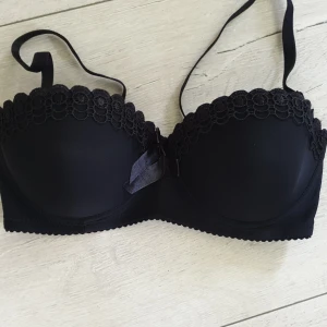 BH NY - Ny bh i svart med fina spets detaljer. Storlek XL med avtagbara axelband. 30kr eller 52kr med frakt.