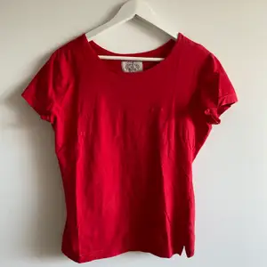 En röd Giorgio Armani t-shirt som jag köpte för några år sedan och som jag tyvärr inte använder idag. Tröjan är fortfarande i mycket gott skick och passar för de flesta tillfällen. Tröjan är i storlek XL men har passformen M