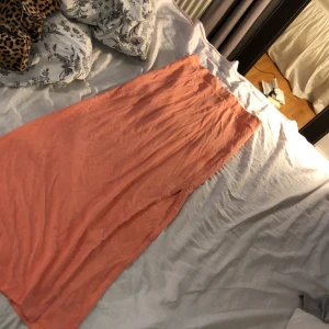 Långkjol stl xs - En aprikosfärgad långkjol med en slitt längst benet från vila i stl xs