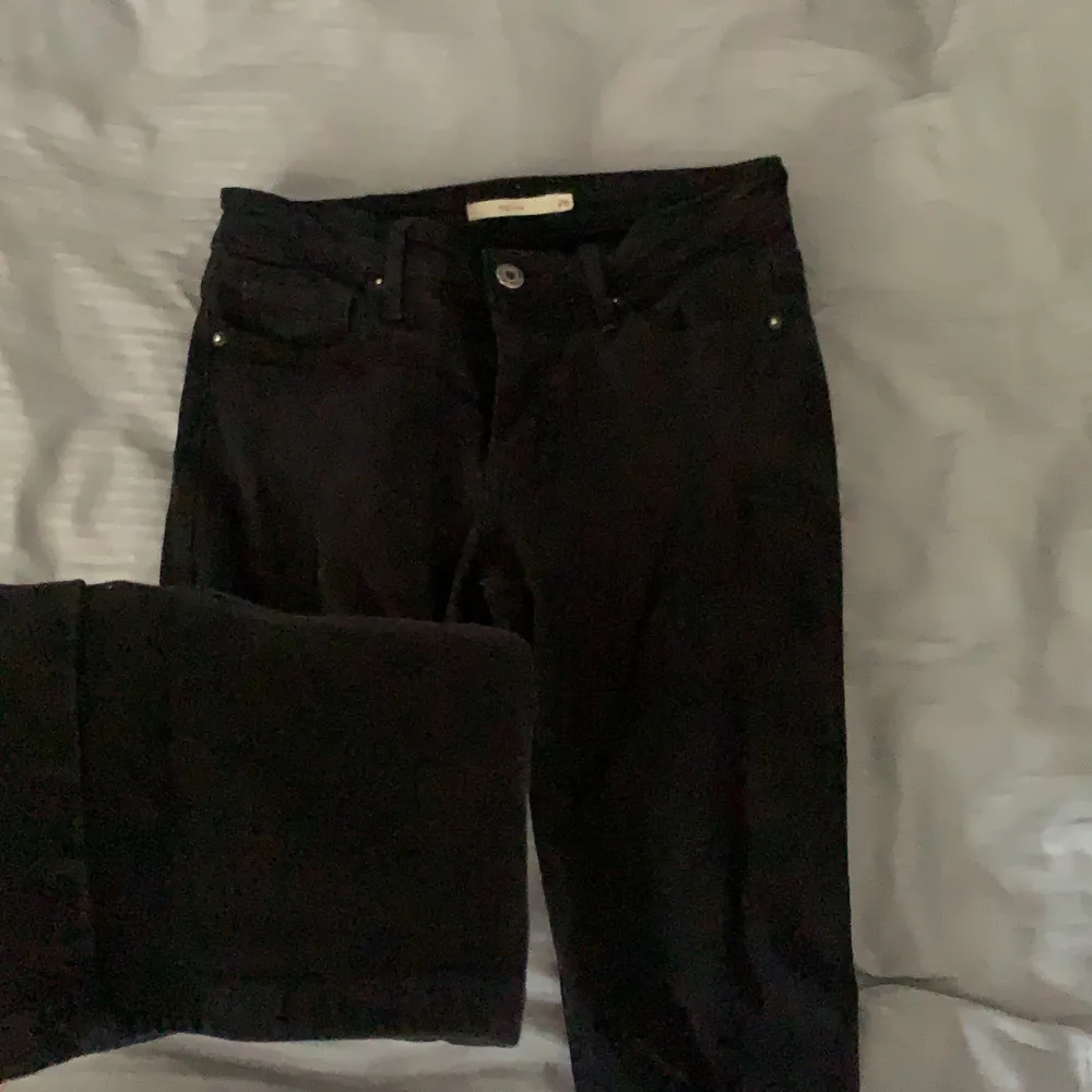 Svarta Levis jeans. Med en liten skroma där knäskålen sitter. Storlek 26, lågmidjade . Jeans & Byxor.