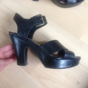  - Svarta högklackade skor i äkta skinn. Väldigt bekväma (jag har kunnat ha dem på två baler utan ont i fötterna). Nyligen omklackade (se bild).  Storlek 38. Inköpta på Din Sko för 499 kr.