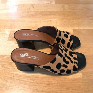  - Sandaler i mockaimitation med djurmönster, använda endast inomhus. 