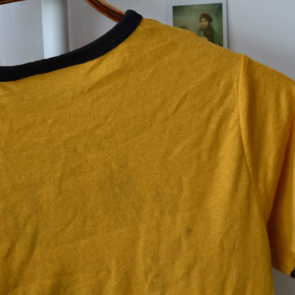 Härlig T-shirt med 70-talsvibes från Urban Outfitters som tyvärr är för liten för mig. Trycket från framsidan har gått lätt igenom och kan ses som en tunn skugga på baksidan men inget man tänker på, se sista bilden. 🌻. T-shirts.
