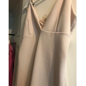  - Figursydd klänning i stretchmaterial. Beige färg 