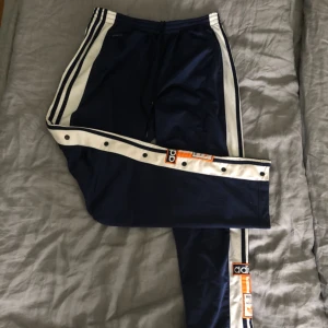  - Dessa Adidasbyxor är köpta på 90talet men tyvärr knappt använda därav priset. Knapparna går att knäppa upp på sidorna och snöre i midjan så dem passar strl M med. Möts i Sthlm 