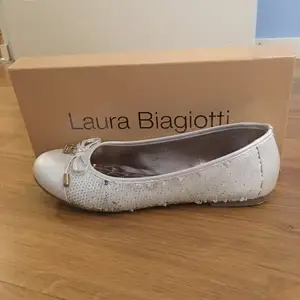Skit snygga ballerina skor från Laura Biagiotti. Vita med paljetter på sidorna som man kan ända till guld eller vit. Guld detaljer. Perfekta skorna till vilken klänning som hälst.   Använda någon timma vid ett tillfälle!!!  Nypris: runt 400kr