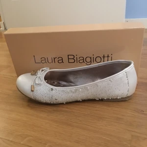  - Skit snygga ballerina skor från Laura Biagiotti. Vita med paljetter på sidorna som man kan ända till guld eller vit. Guld detaljer. Perfekta skorna till vilken klänning som hälst.   Använda någon timma vid ett tillfälle!!!  Nypris: runt 400kr