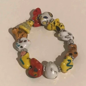  - Ett häftigt handmålat armband i olika färger med olika figurer. Med gummiband så den är töjbar. Knappt använd, super fin! 