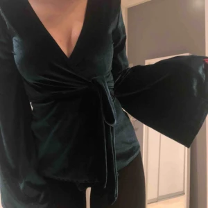  - Super fin smaragdgrön omlott topp i sammet! Den har vida armar och sitter riiiktigt snyggt! (Bilder a ger inte toppen rättvisa i färg! Den är perfekt till vardag och till fest