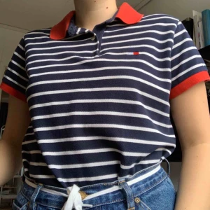  - säljer äkta vintage tommy hilfiger piké! supersnygg randig tröja i mörkblått med röda detaljer! frakt tillkommer