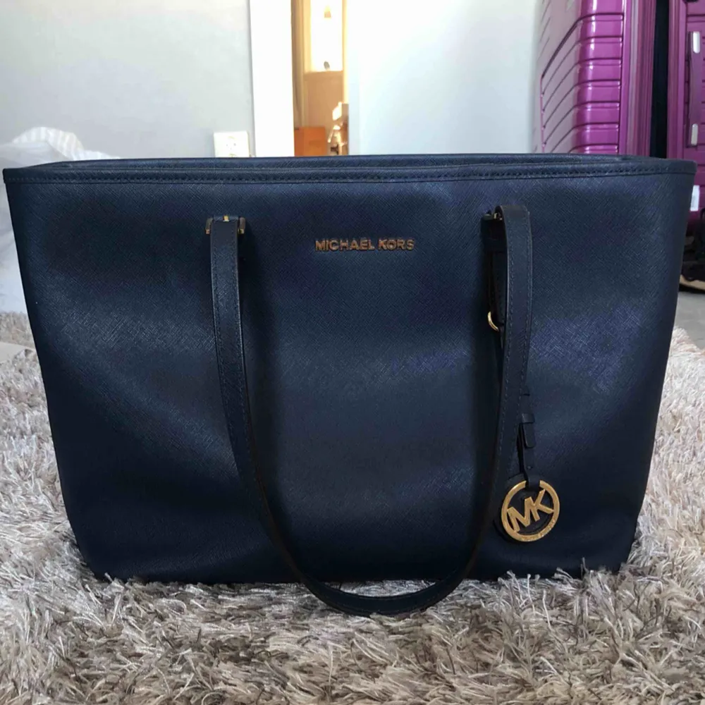 Äkta Michael Kors väska i marinblått och gulddetaljer. Superfint skick då jag knappt använt den. Köpt för ca 3000kr för 3 år sedan.. Laukut & Käsilaukut.