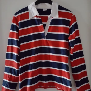  - Blå, vit, röd randig tröja i storlek L, dock mindre och mer som ca S/M. Lite missfärgad på kragen (se andra bilden), kanske går bort i tvätten. Fraktkostnad blir 66kr. 