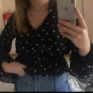  - Mörkblå blus med vita prickar, resår runt midjan och knappar framtill💙 