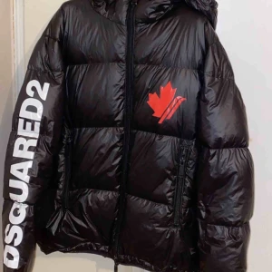  - Dsquared2 Puffer Down Jacket Black  Beskrivning: Down jacket från Dsquared2 i  en sportig modell med luva.   Storlek M  Detaljer: Svart Bra skick  100% äkta   Nypris: SEK 7,299  Pris: SEK 3800