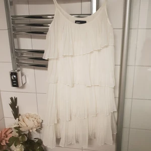  - Fin vit klänning med volanger. Bra skick! Endast använd ett par gånger.   Frakt tillkommer 💕