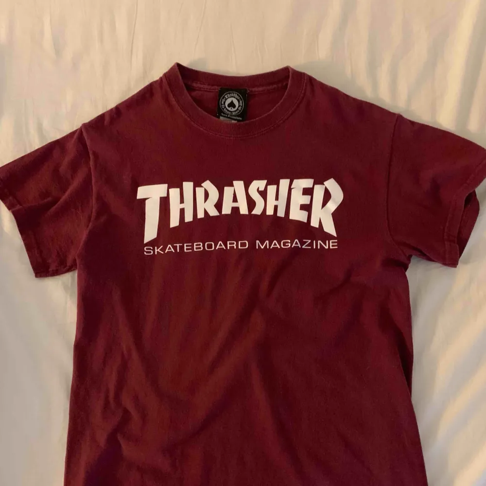Vinröd thrasher t shirt storlek small. T-shirts.